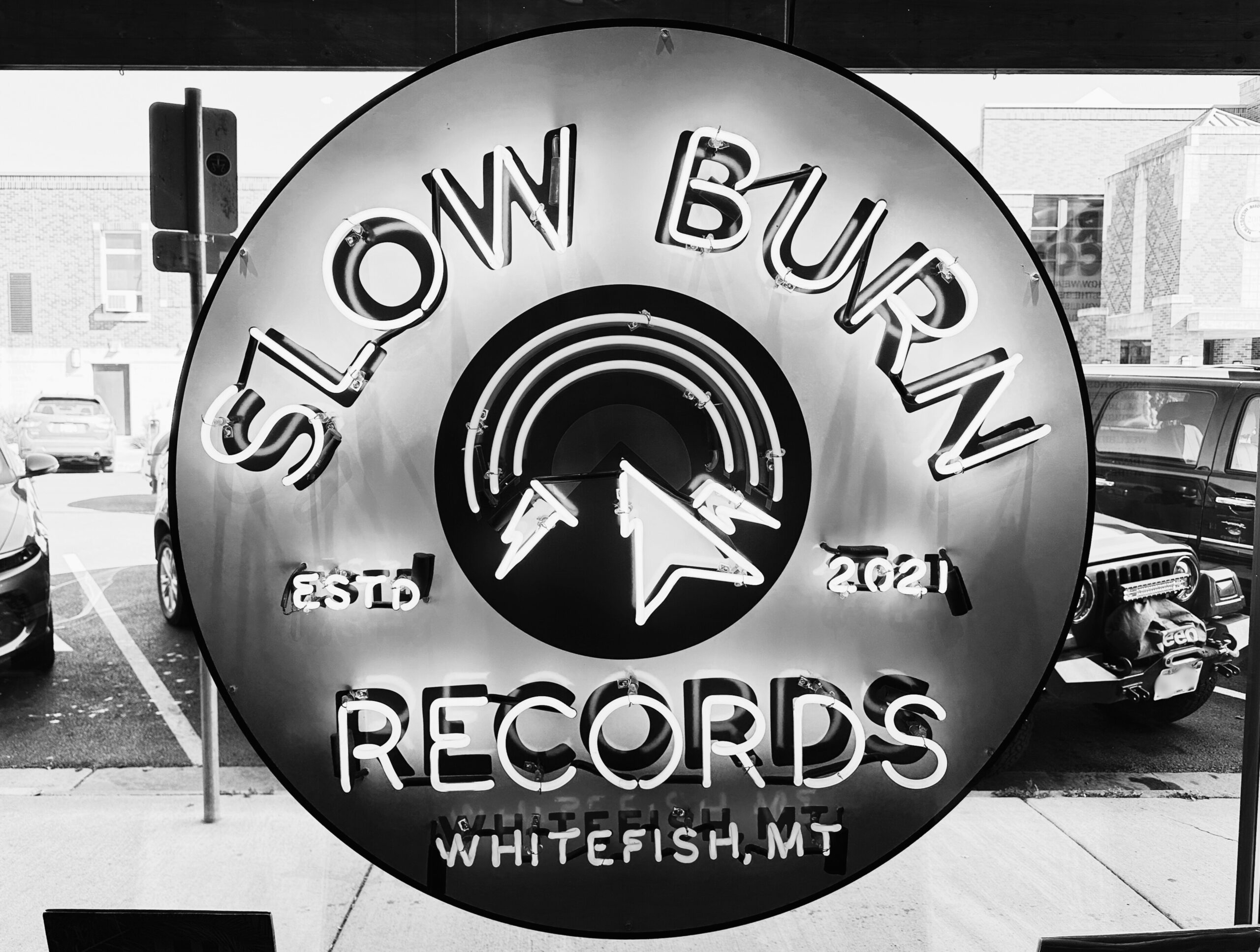 Black-and-white photo of neon sign reading Slow Burn Records