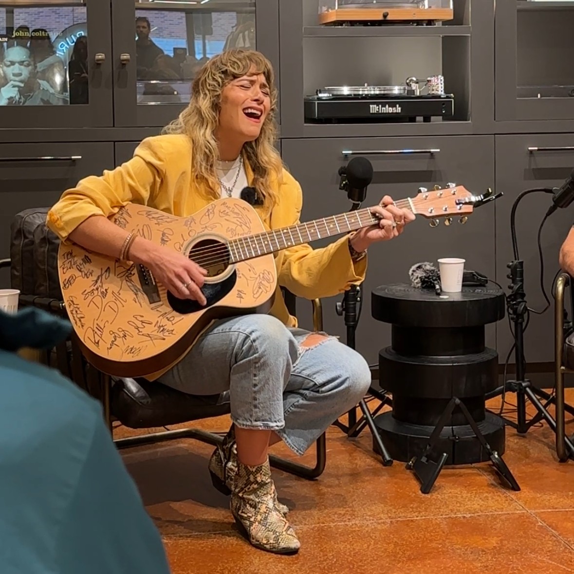 Blonde woman sings while playing the guitar